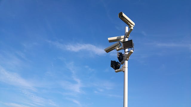 Sicherheitskameras / Videoüberwachung von Werksgelände. Im Hintergrund blauer Himmel.