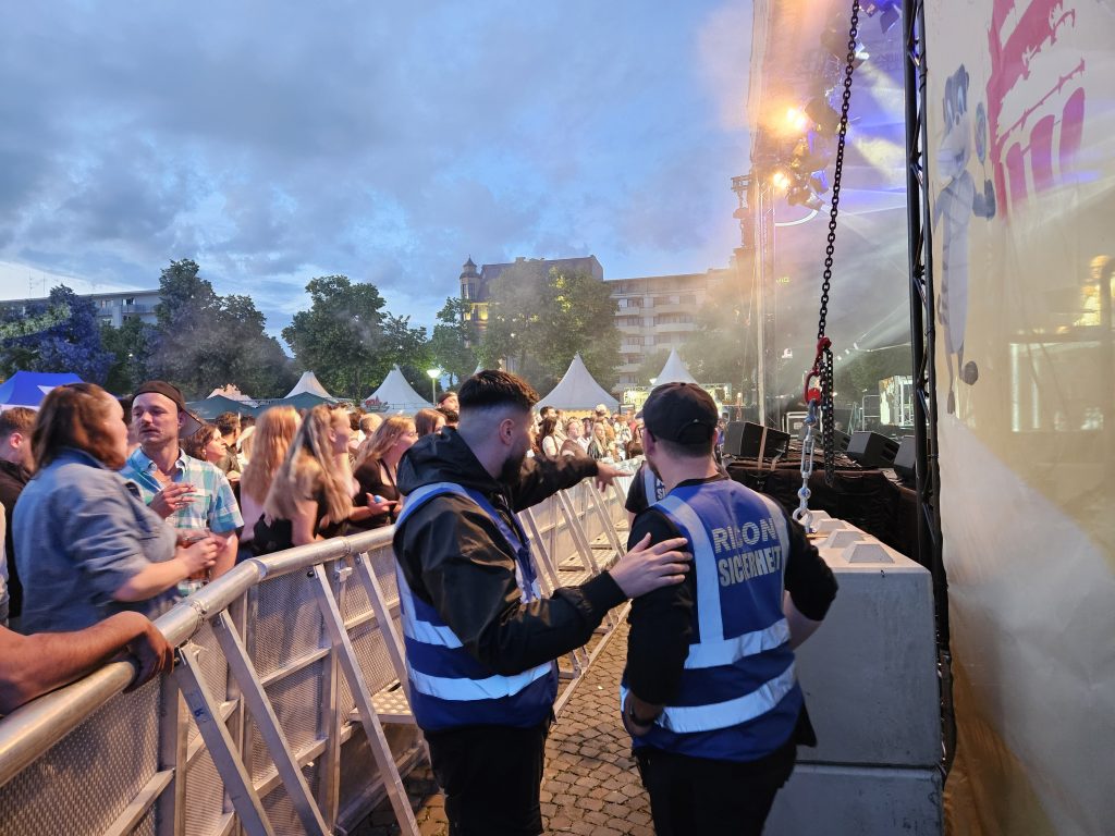 Ein Sicherheitsmitarbeiter / Security im Bühnengraben beim Stadtfest Mannheim weißt einen Kollegen auf einen Sicherheitsverstoß hin.