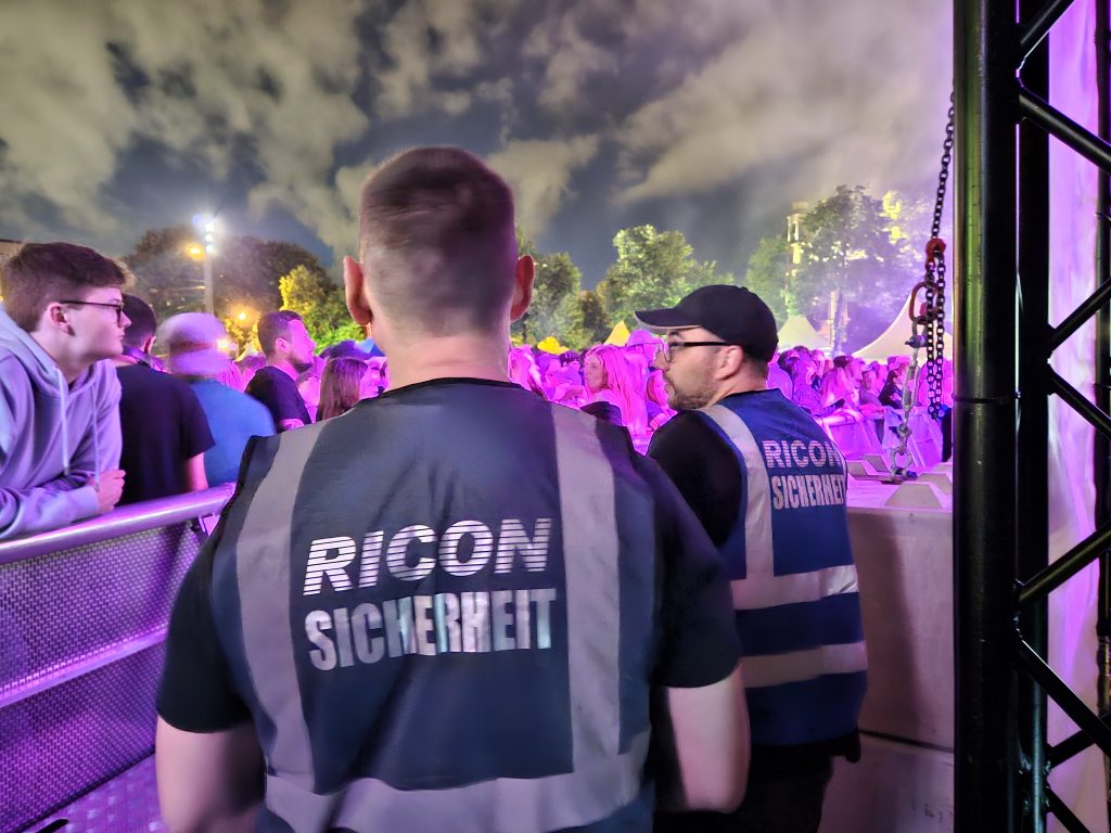 Zwei Sicherheitsmitarbeiter / Securitys im Bühnengraben beim Stadtfest Mannheim beobachten die Gäste.